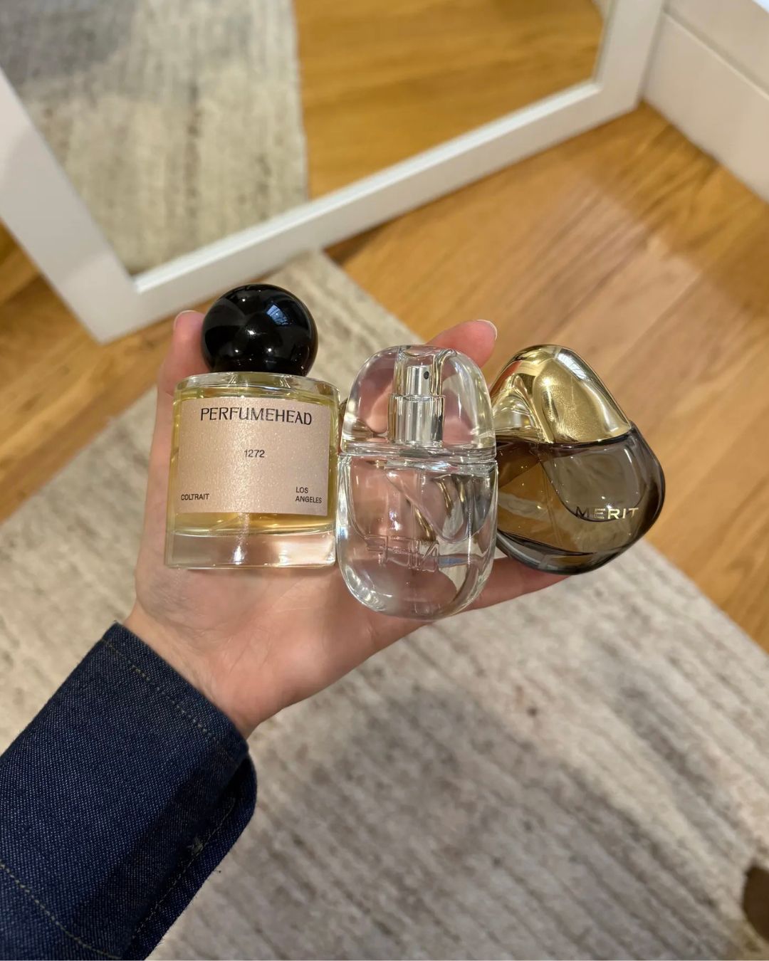 An image of WWW senior beauty editor holding fragrance essences and perfumes.