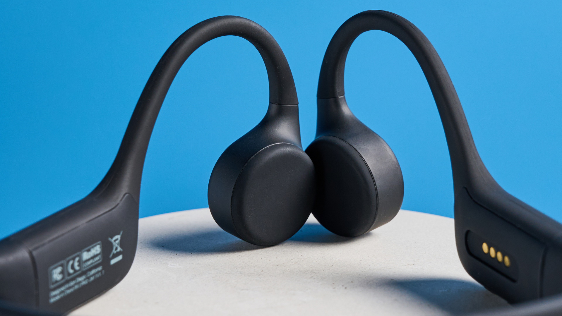 H2O Audio TRI 2 PRO headphones photographed in front of a blue background