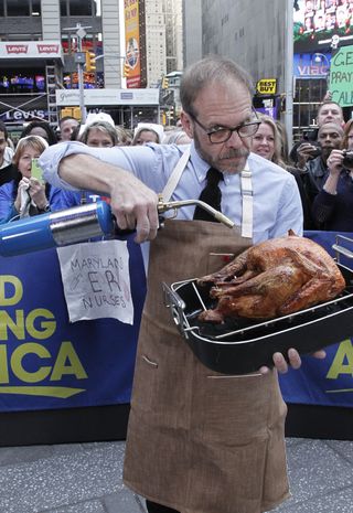 alton brown showing off a turkey on good morning america to promote good eats