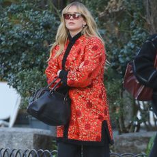 Jennifer lawrence wears a red jacket, black pants, and leopard alaia flats.