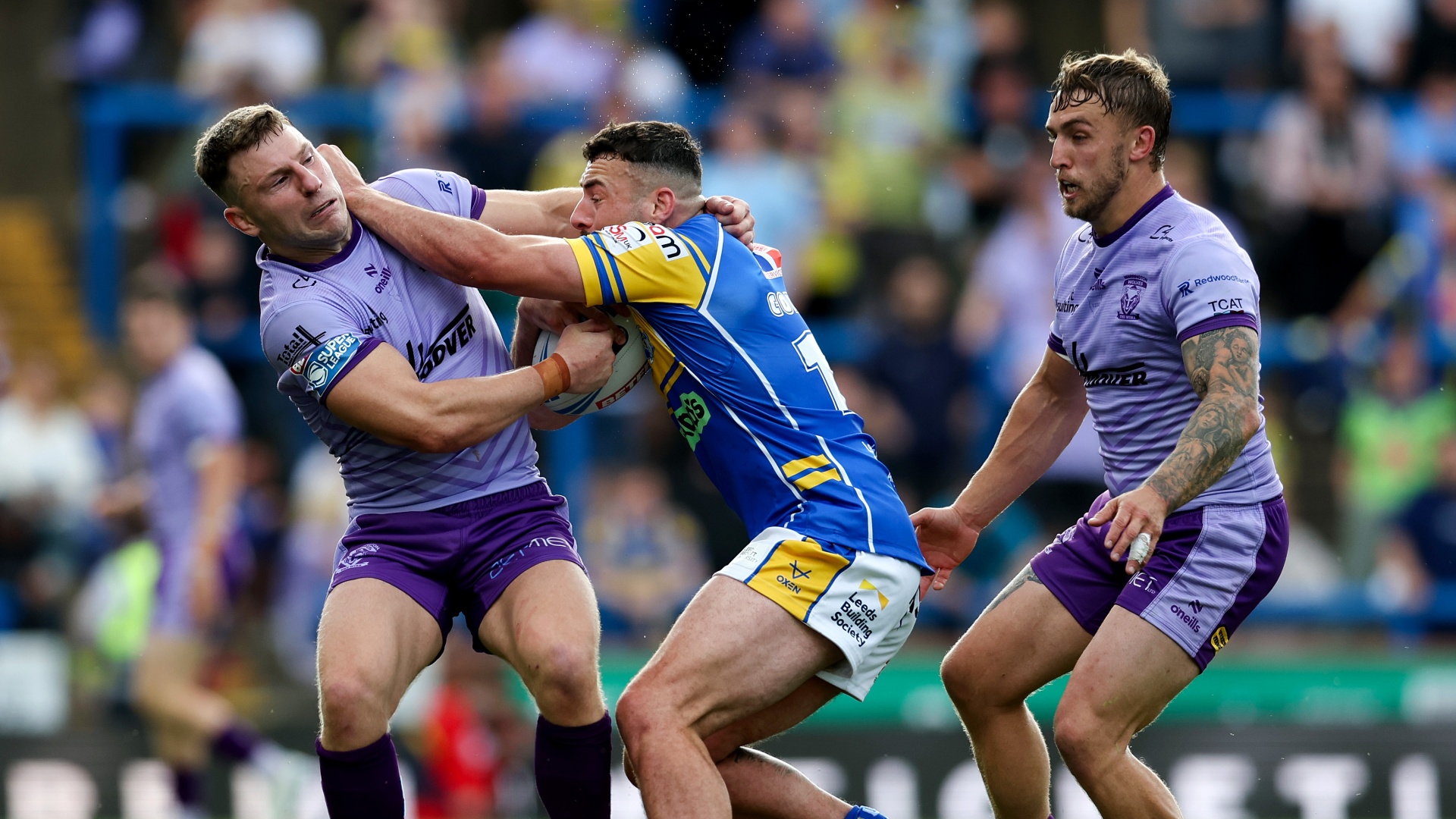 Super League Man of Steel Jake Connor of Leeds Rhinos being tackled by George Williams and Sam Powell of Warrington Wolves