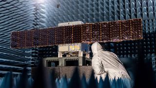 an illustration of a cube-shaped spacecraft with two wing-like solar panels