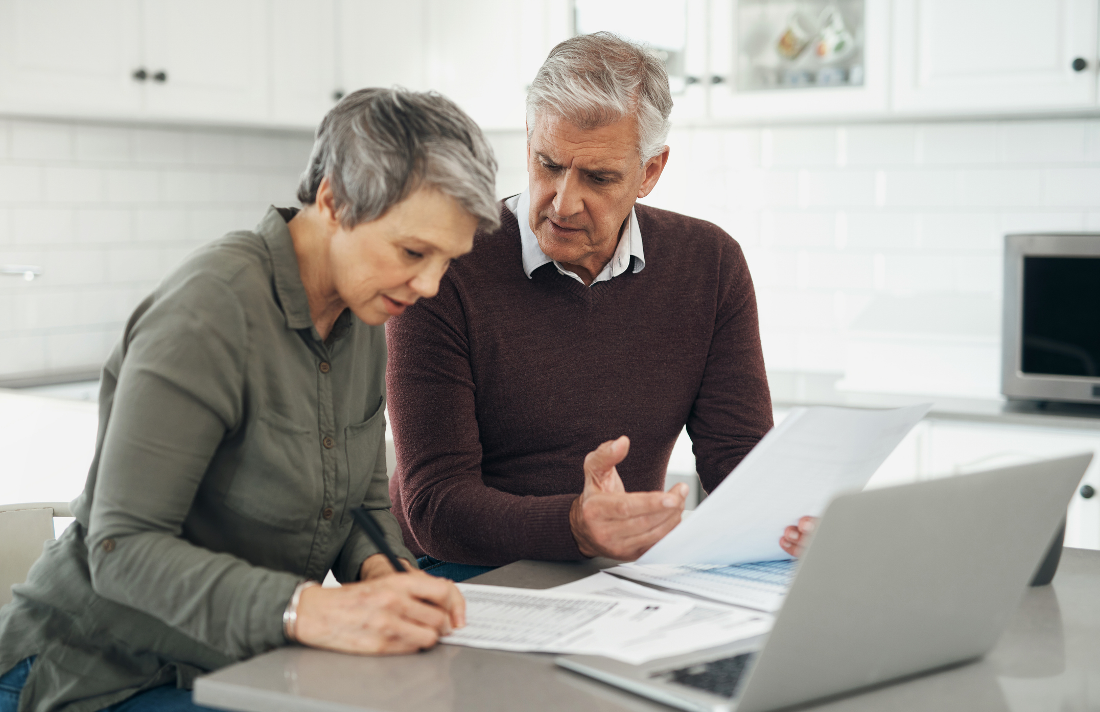 Retired couple with paperwork for home finance, checking their pension fees