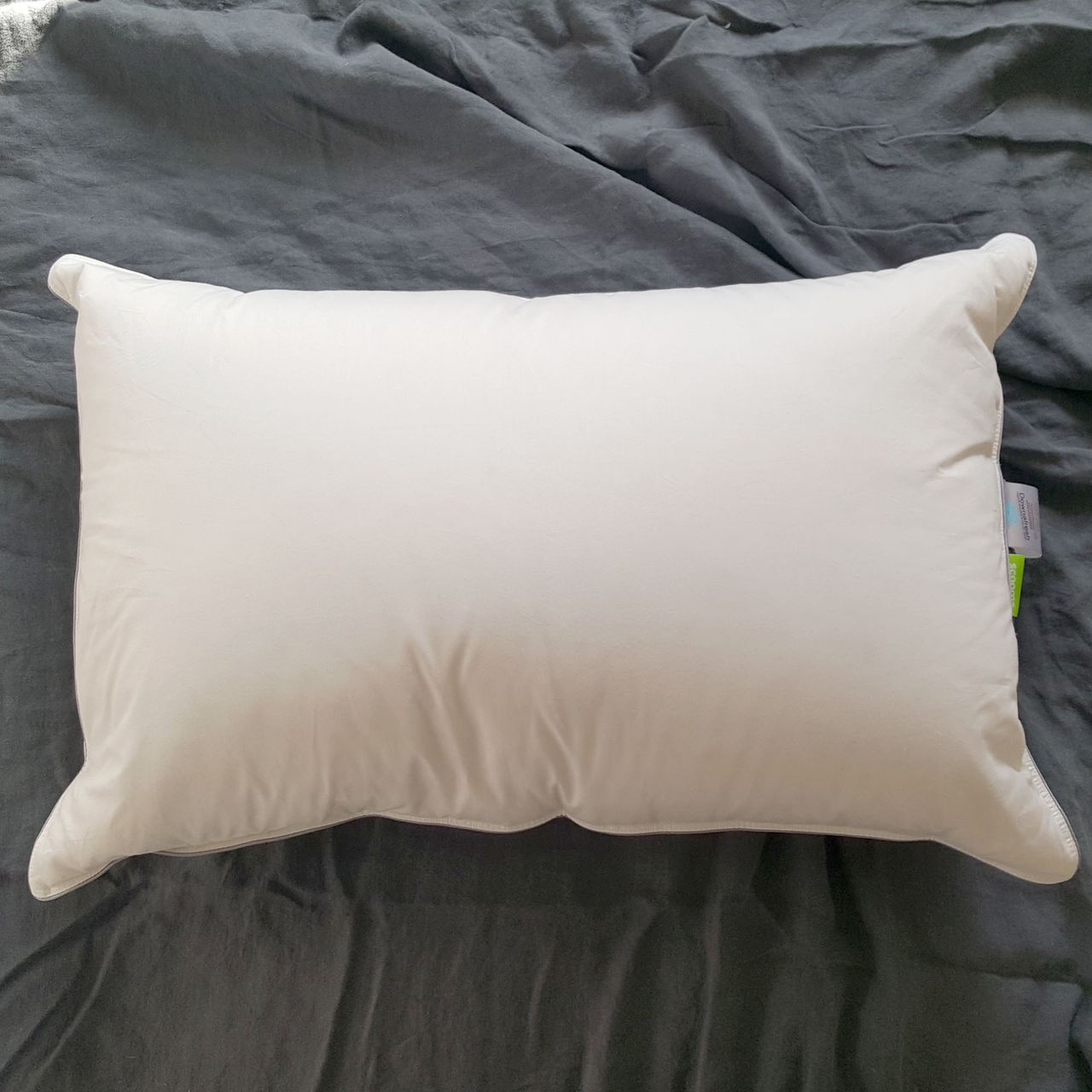 Plump white scooms Hungarian Goose Down pillow on a bed with grey bedlinen