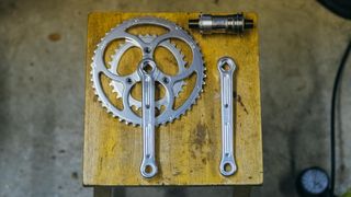A set of Rene Herse square taper cranks on a wooden stool