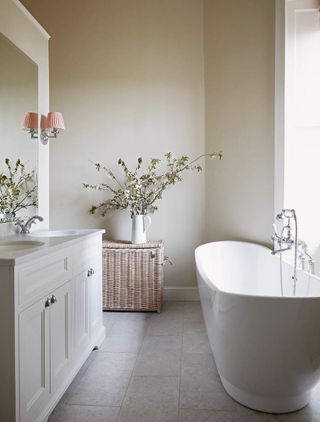 A beige bathroom with a freestanding vanity and a bath