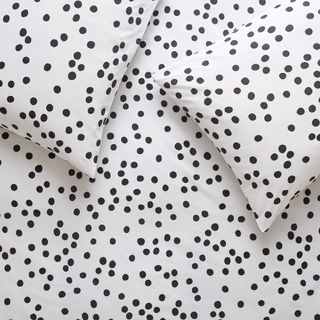 white bedding set with printed black dots on bedsheet and pillow covers