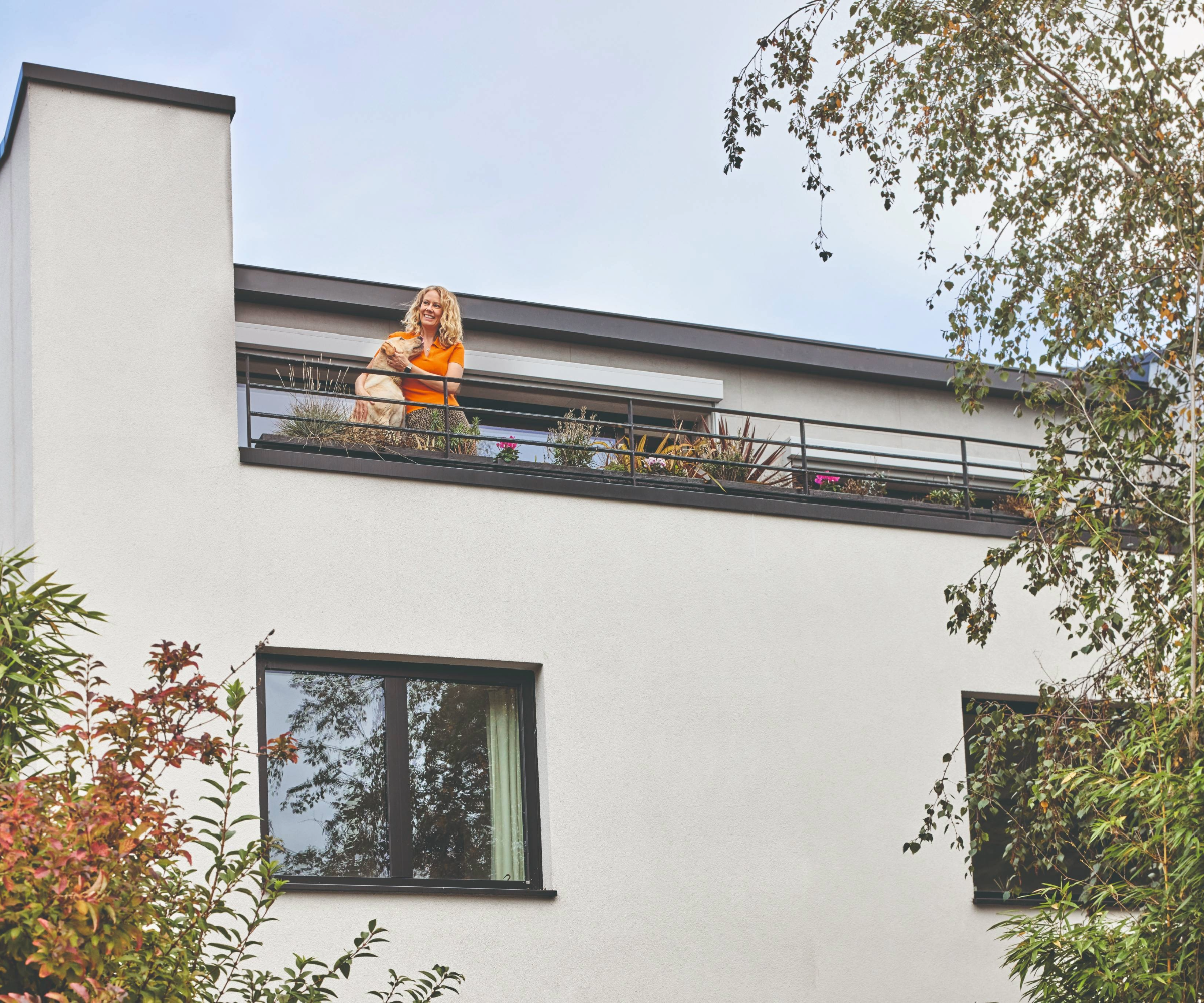 Woman and dog on balcony of passivhaus building