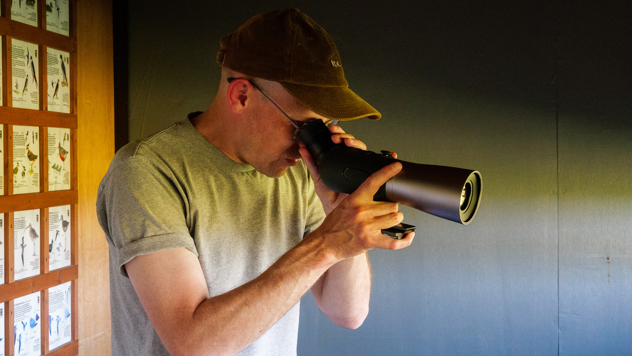 Bird spotting scope on tripod in bird watching hide