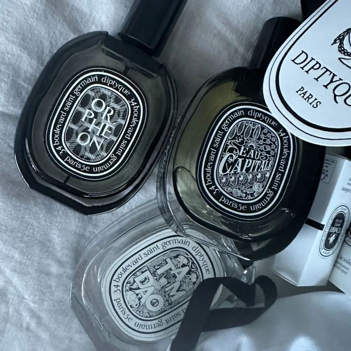 An image of several Diptyque perfumes pouring out of a bag