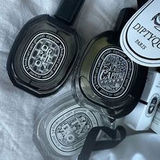 An image of several Diptyque perfumes pouring out of a bag