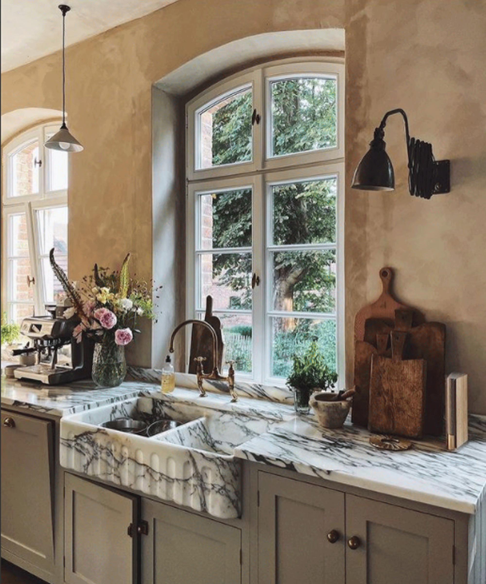 Kitchen with pink walls and deeply veined marble on the sink and worktop