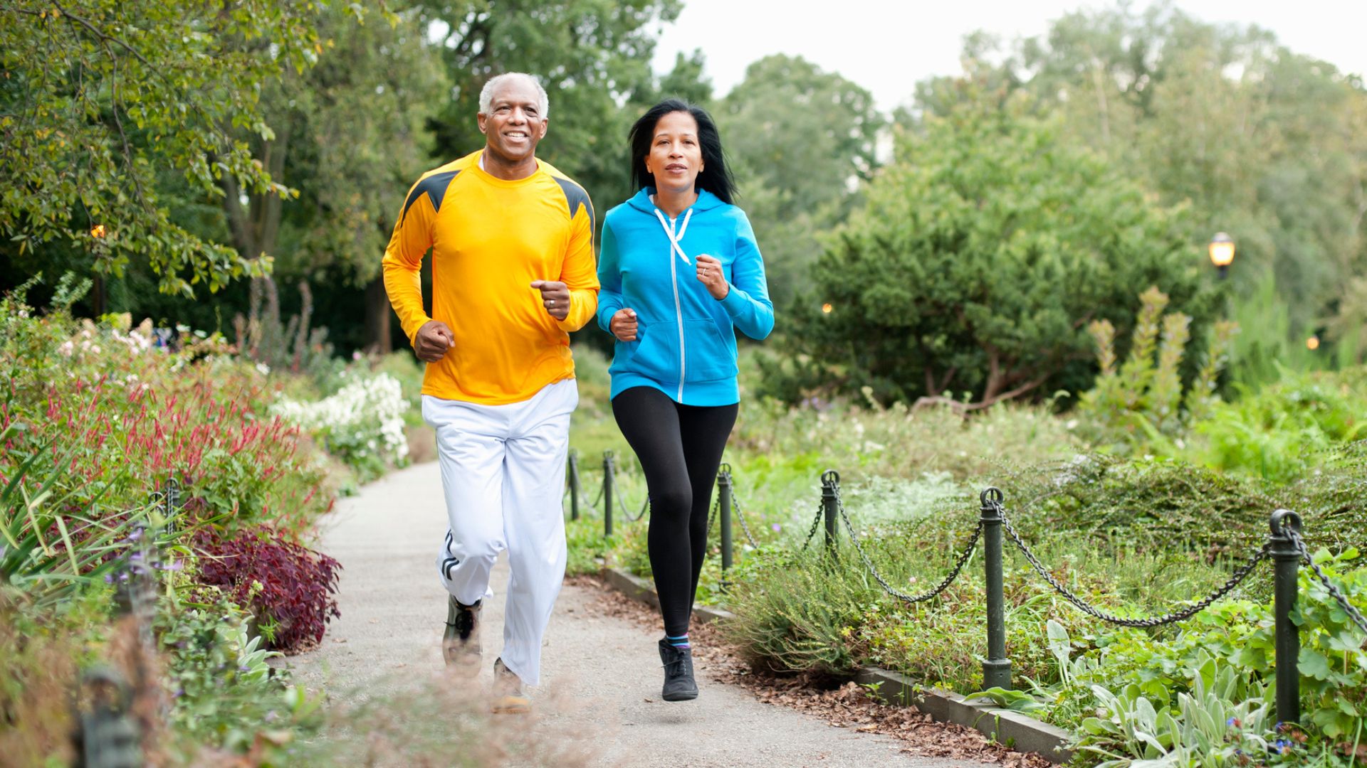 older couple run together in a park