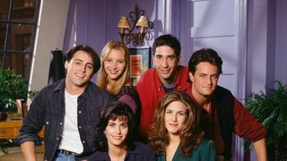 The whole Friends gang in front of the iconic purple walls of Monica's apartment