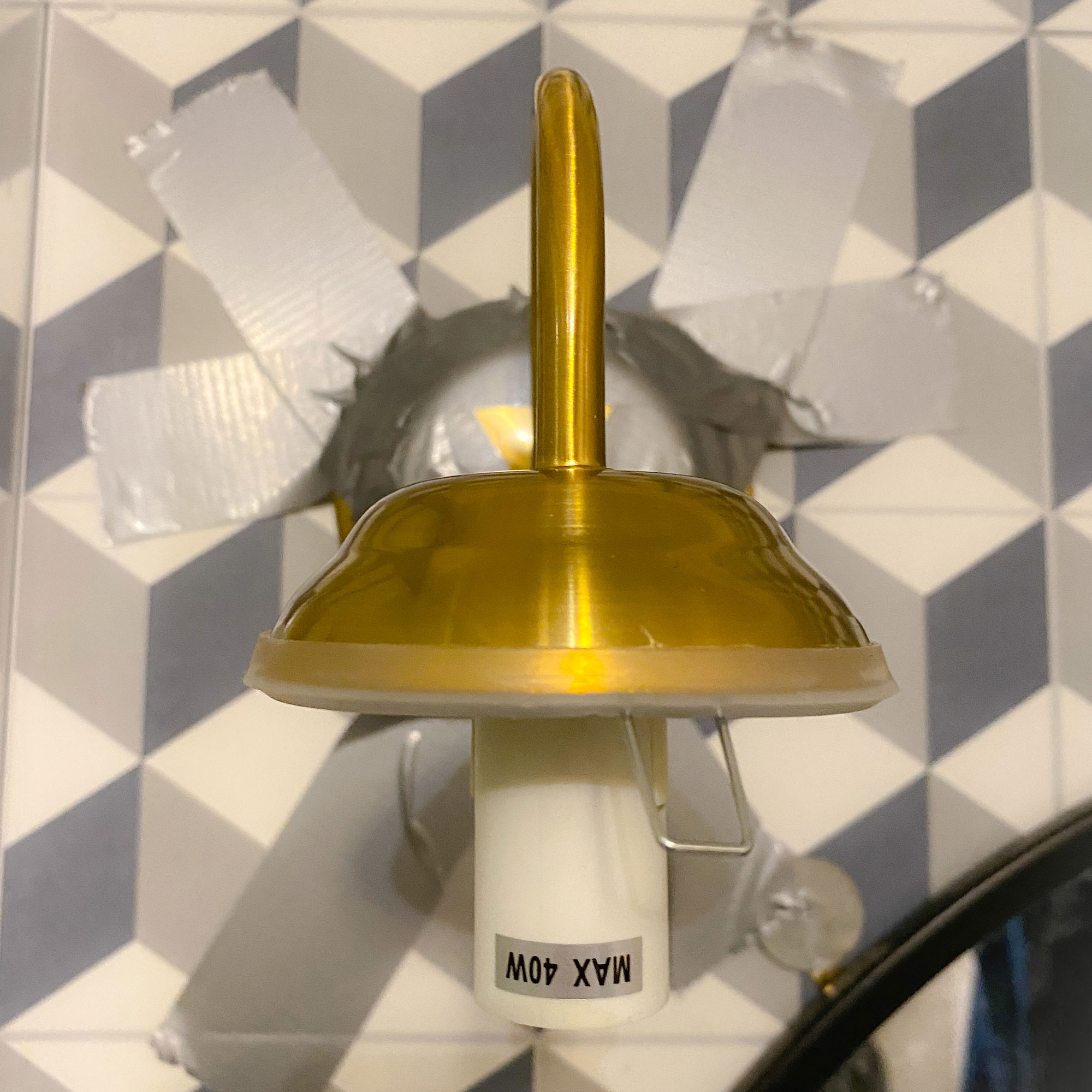 Wall light without shade in place being held up with duct tape