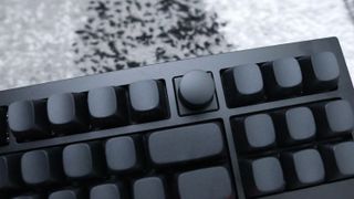 The Keychron Q3 Max gaming keyboard set-up on a desk with the RGB lighting enabled.