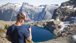 Man studying GPS device, possibly wondering "what is a GPX file?"