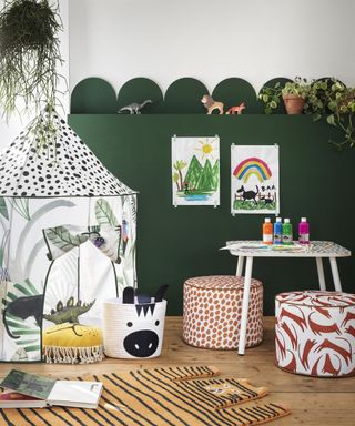 Playroom design by Habitat with green scallop wall decor, kids paintings and spot motif play tent