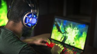 A PC gamer playing a game on a gaming laptop