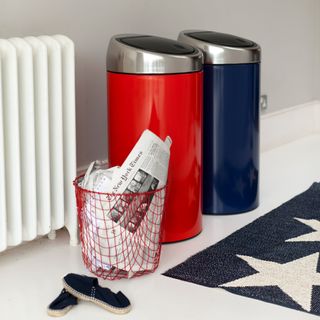Red and blue kitchen bins beside wire waste paper basket