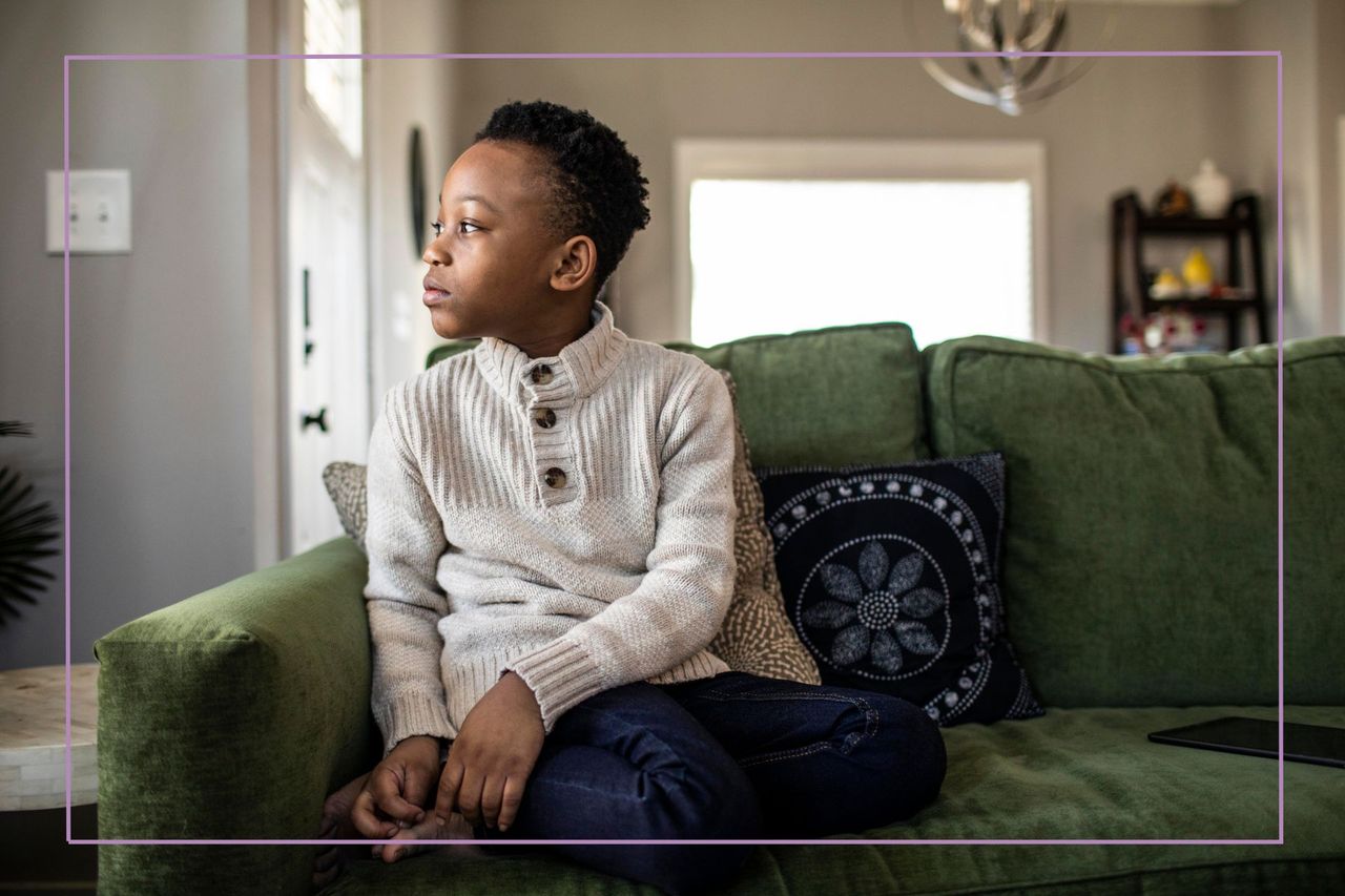 Boy sat on sofa looking unsure