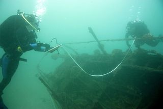 Divers map an unidentified vessel found during the survey of the former military training site.