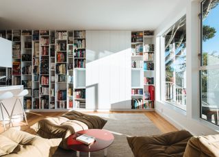 Floor to ceiling bookcase filled with books in a white apartment