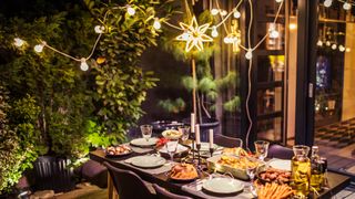 Outdoor area with dining table dressed foready for an outdoor Christmas party theme