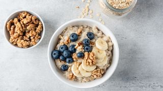 oatmeal with blueberries, bananas and walnuts in a ceramic bowl