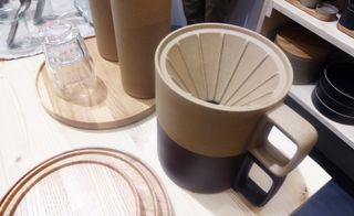 A porcelain dripper mug on a wooden table.