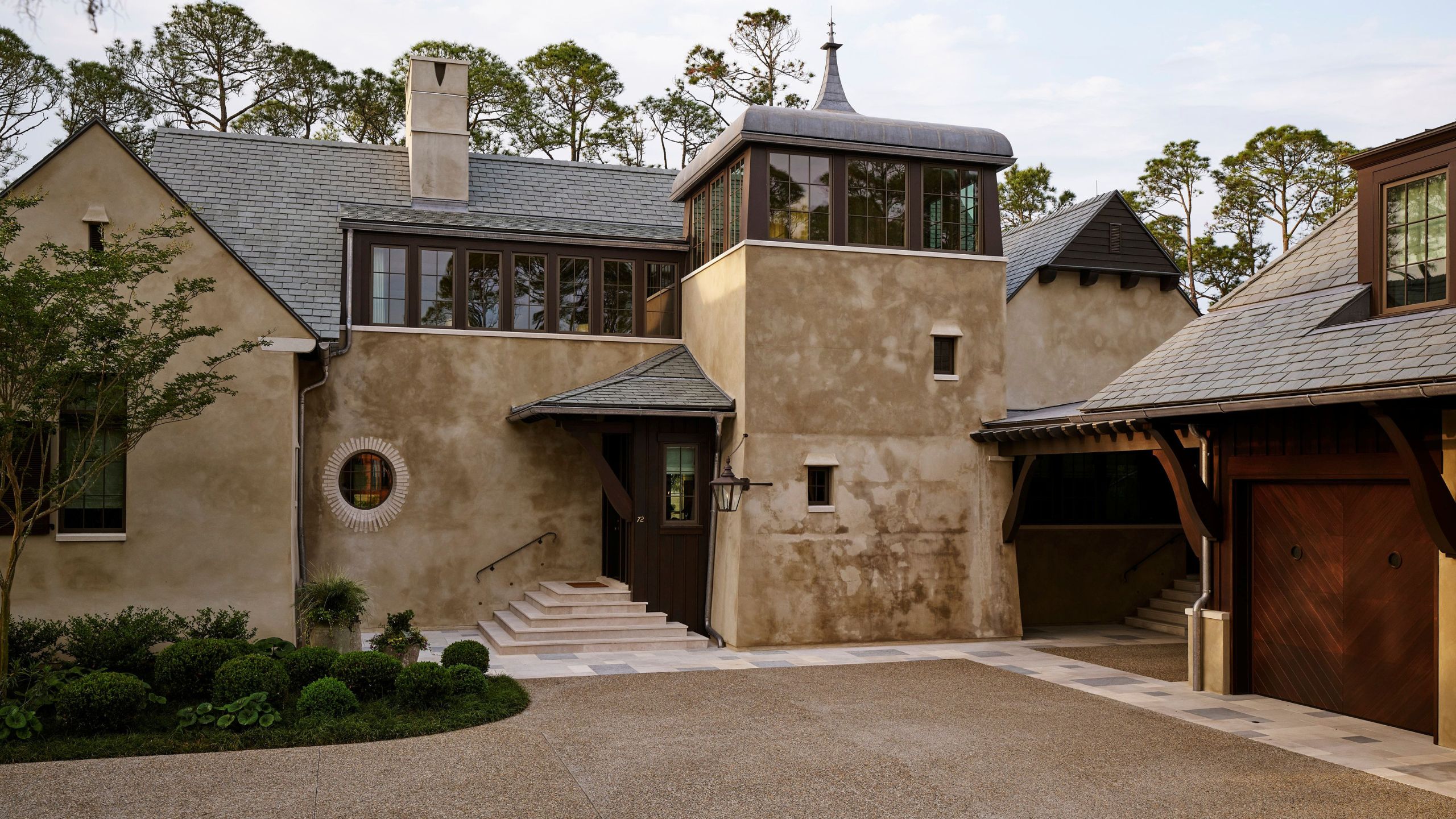 a large stone new build home in Kiawah Island with pitched roofs and dramatic entry