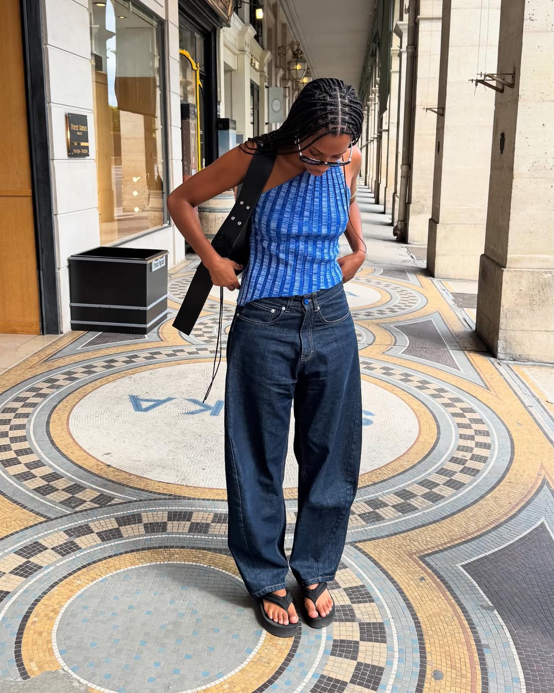 Claire in barrel-leg jeans and blue top