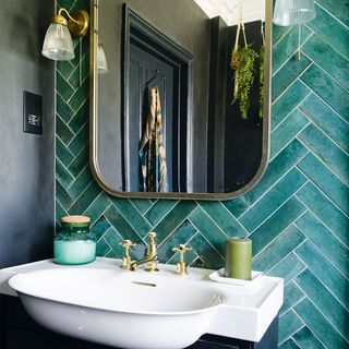 bathroom with green tiles and basin