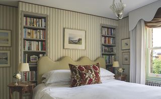 master bedroom with striped wallpaper in an extended Victorian cottage