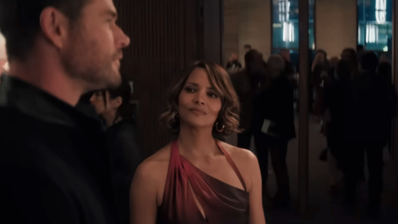 Halle Berry in a red dress smiling and looking at Chris Hemsworth