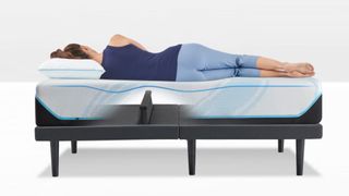 A woman in blue top and trousers sleeping on her side on Tempur-Pedic mattress on Tempur-Ergo smart bed base