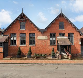 school house with brick wall and shrubs