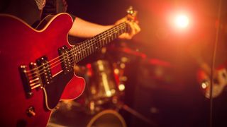 Person playing the electric guitar live on stage