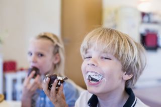 Two children with marshmallows in their mouths