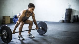 Woman doing deadlifts at gym