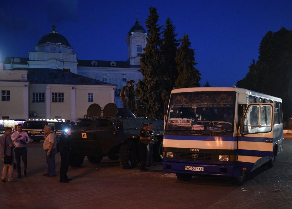 Servicemen and law enforcement officers gather at the scene after police freed all hostages from a bus and arrested the armed man who held them for over 12 hours in the city of Lutsk, some 40