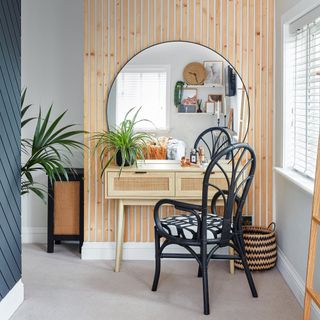 dressing table in front of wooden wall panelling with mirror and chair