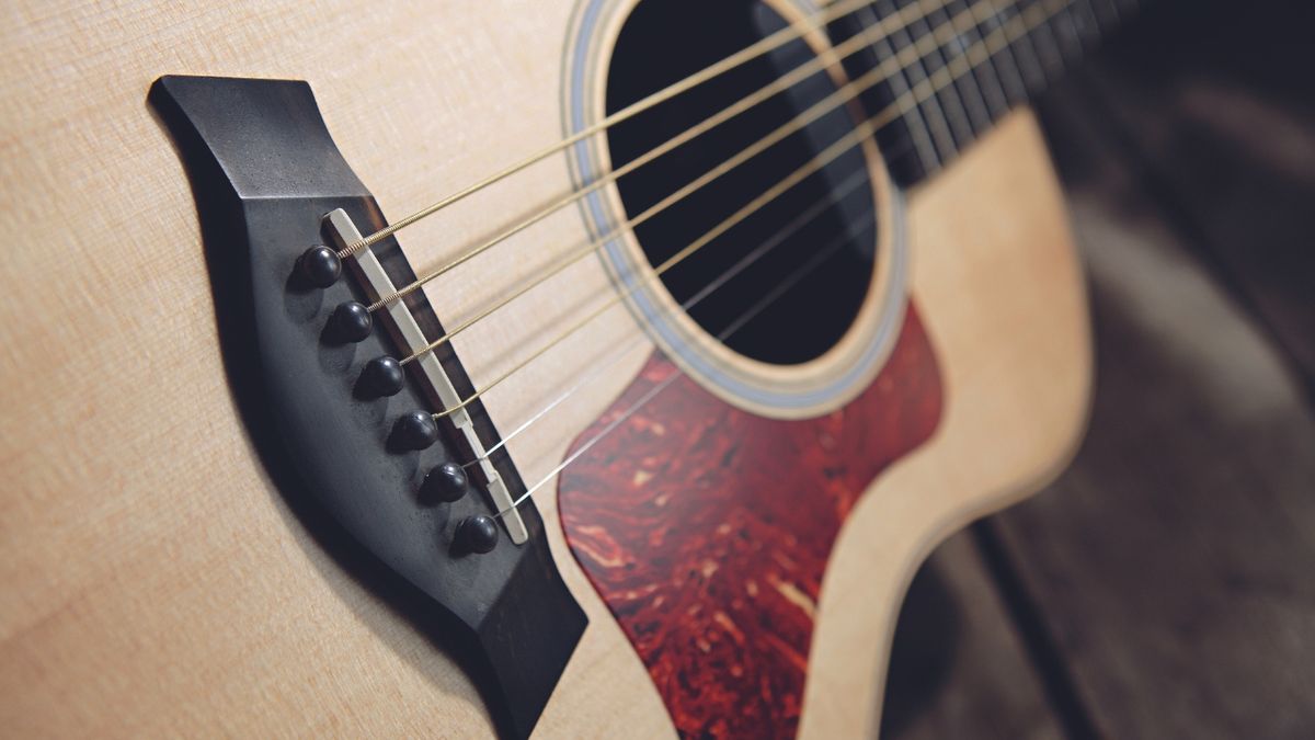 Close up of the bridge, strings, and sound hole of a Taylor GS-Mini acoustic guitar