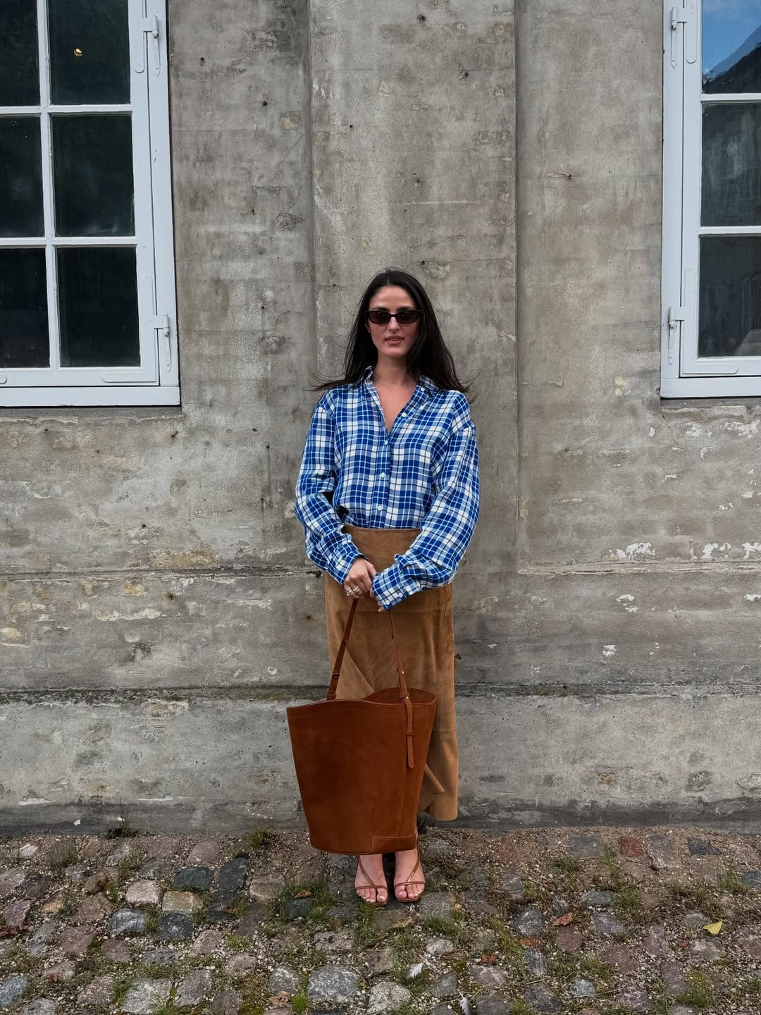 Jordan Goldberg wearing a plaid shirt and suede skirt