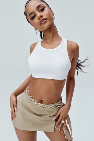 Tyla poses in a white tank top crop top and mini skirt with a chain belt in her Gap spring 2024 campaign