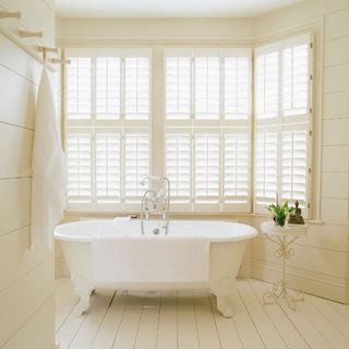 bathroom with white bathtub and floorboard
