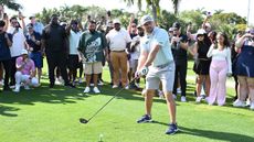 Bryson DeChambeau prepares to hit a drive in front of DJ Khaled and fans at the We The Best Foundation 2025 event