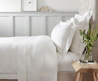 Side view of Santorini Bed Linen Collection on a bed against a white wall.