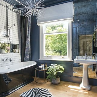 blue bathroom with wood floors and bateau bath