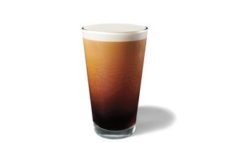 A tall glass of Starbucks Nitro Cold Brew with a foamy milk top